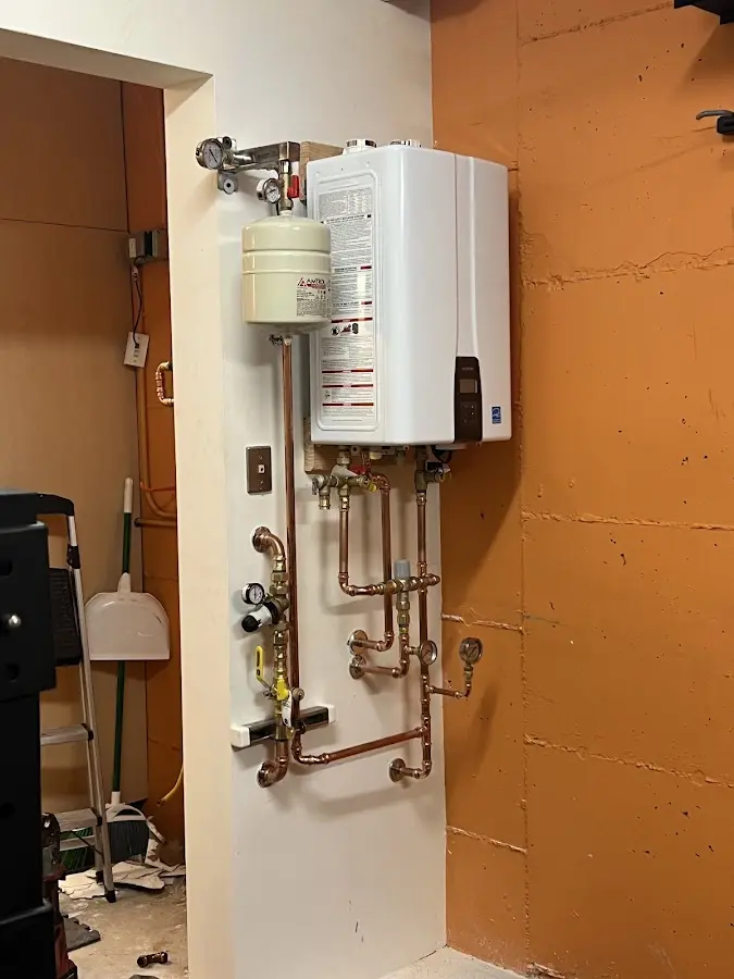Plumbing technician inspecting water heater connections in Cooper City